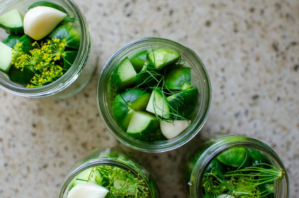prepping sliced cucumbers and dill in canning jars for water bath canning