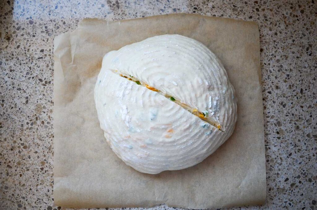 sourdough jalapeno cheddar bread dough with a score down the middle of the dough