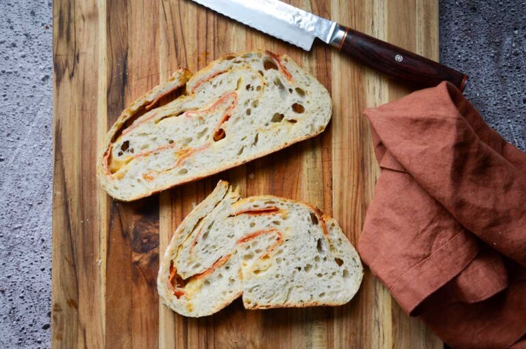 sourdough pepperoni bread slices on a wood cutting board