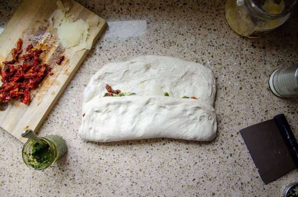 folding the bottom half of the dough up to the middle