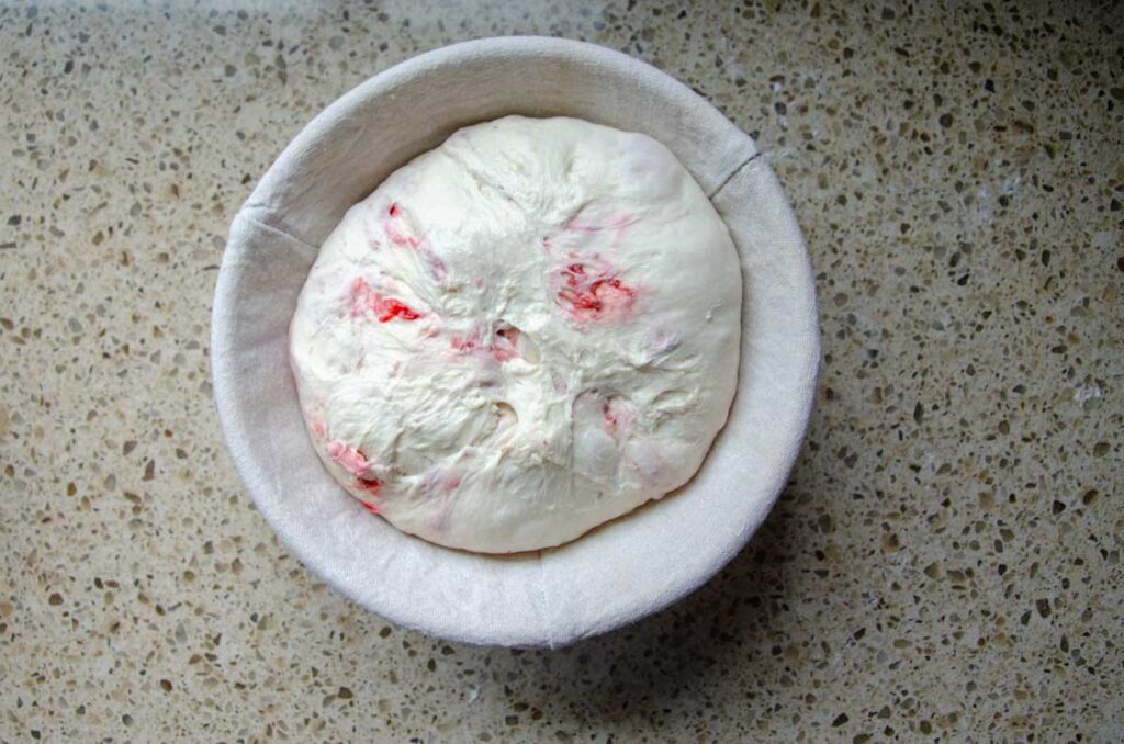 sourdough strawberry bread dough in a proofing basket