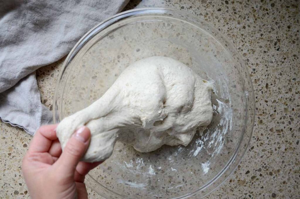 stretching the smooth sourdough pesto sun dried tomato bread dough