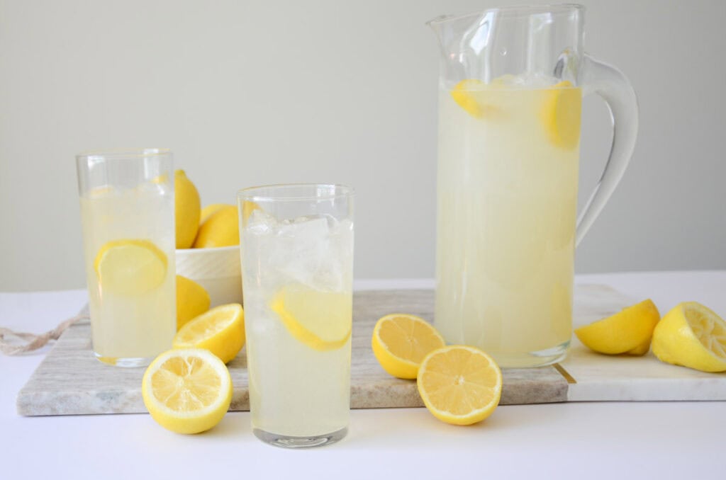 lemonade in a pitcher with two glasses of lemonade