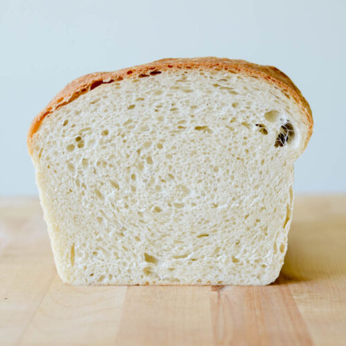 a side voew of a cut loaf of sourdough sandwich bread