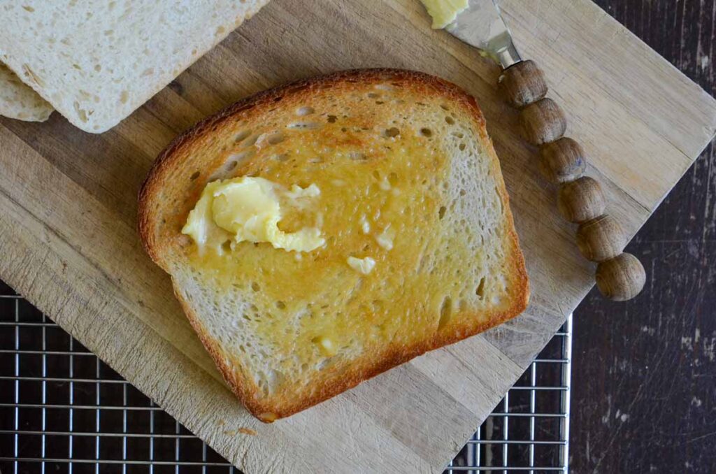 a piece of toasted sourdough sandwich bread on a wooden board