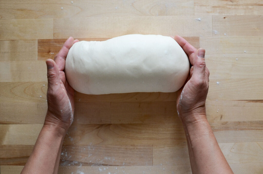 tucking the ends of the bread dough under