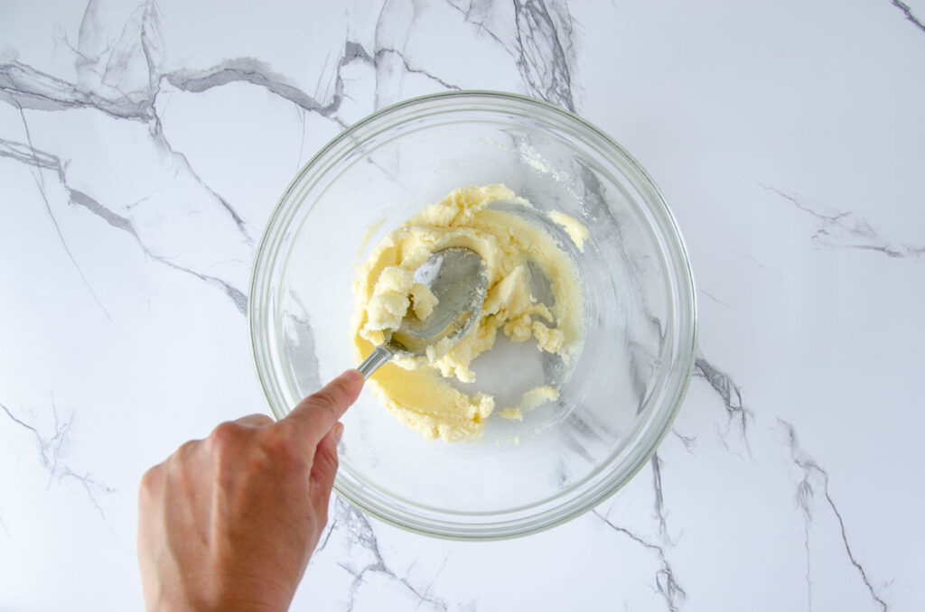 Butter creamed in clear bowl by spoon