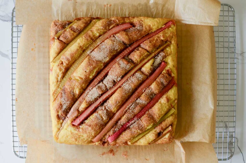 Baked rhubarb cake on parchment paper cooling