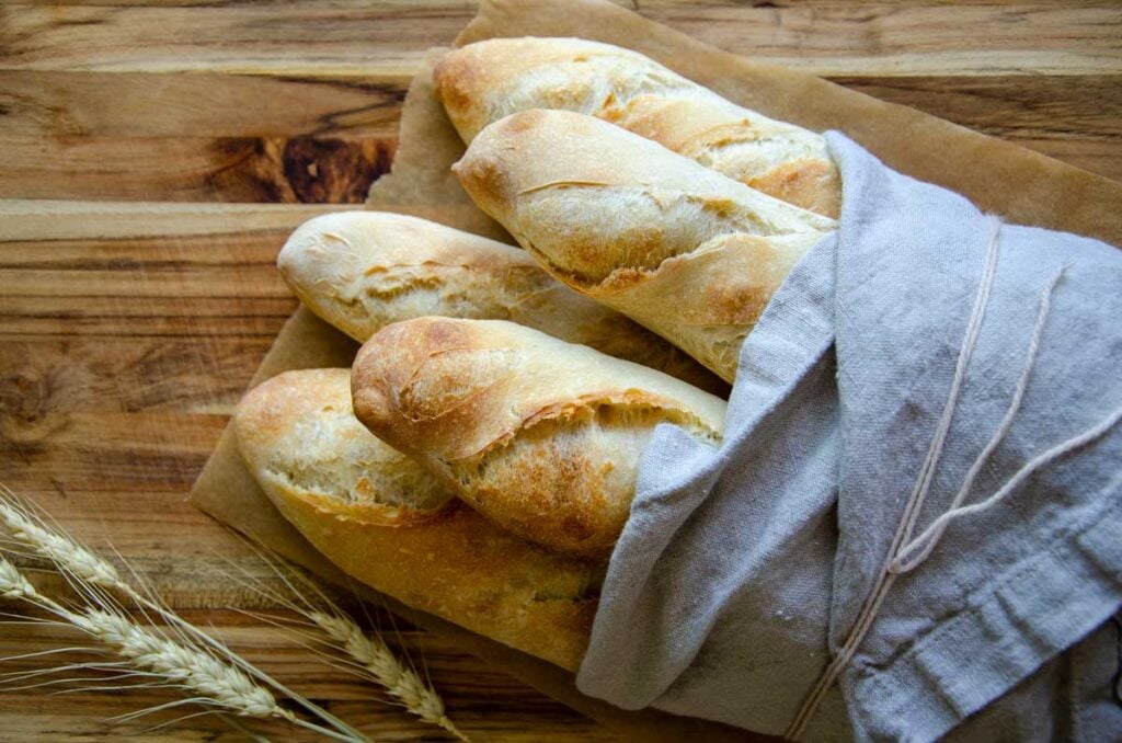 five baguette loaves wrapped in linen cloth
