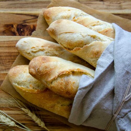 five baguette loaves wrapped in linen cloth