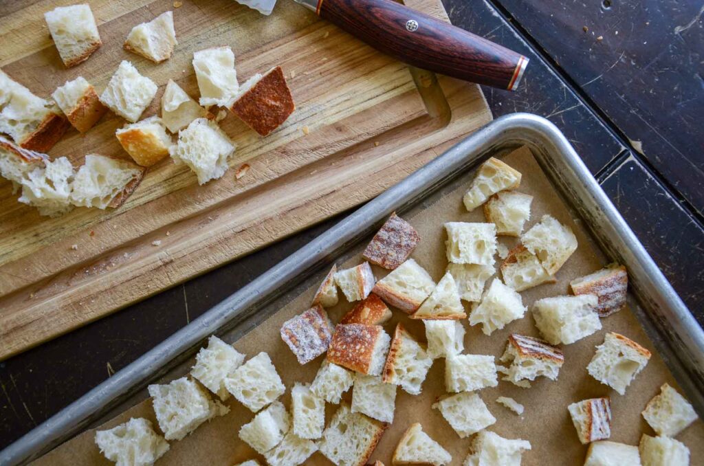 Cubes of sourdough bread on baking tray