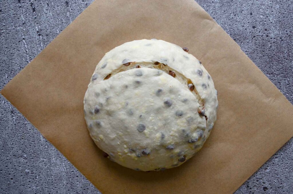 Dough sliced in half moon shape on parchment paper
