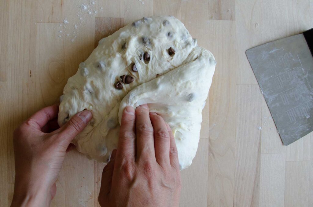 Hands stretching sides of dough into center