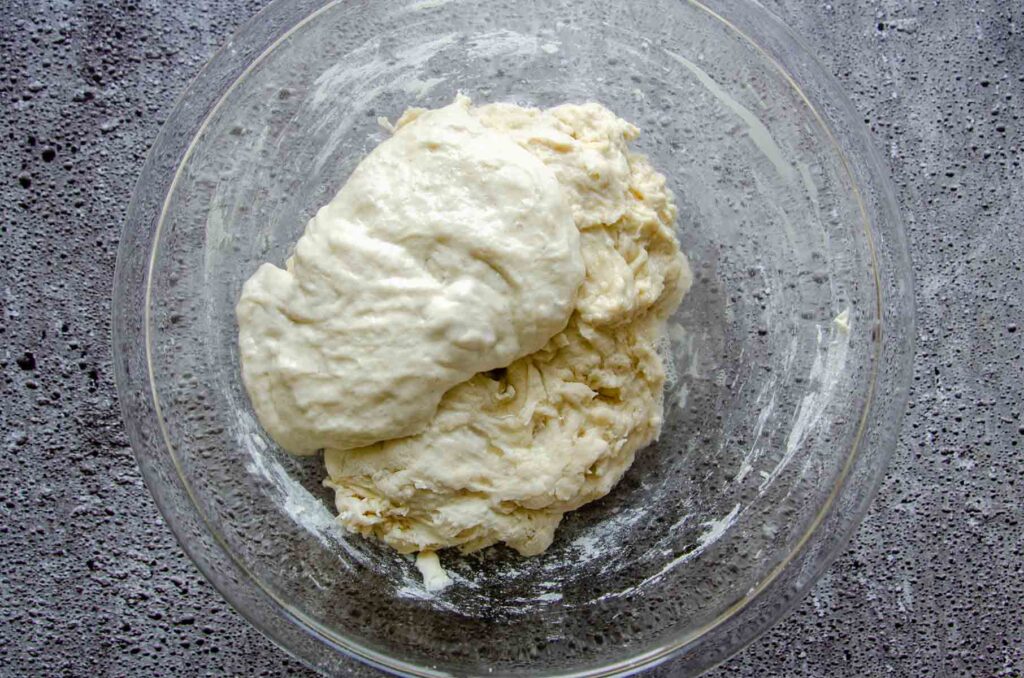 Raised dough in glass bowl on slate