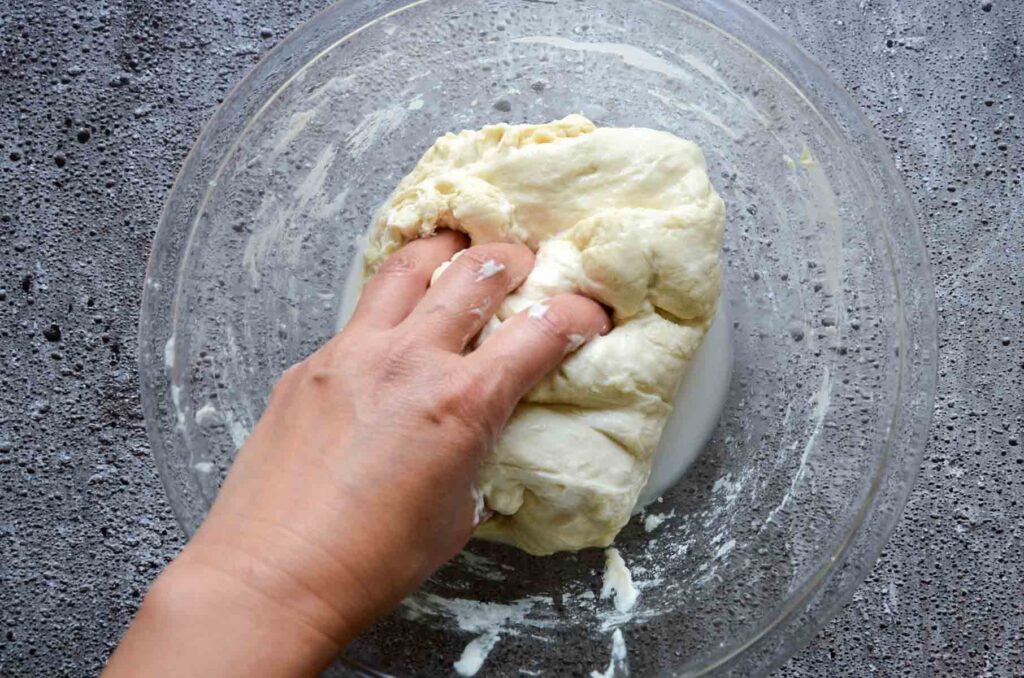 Hand mixing dough in glass bowl