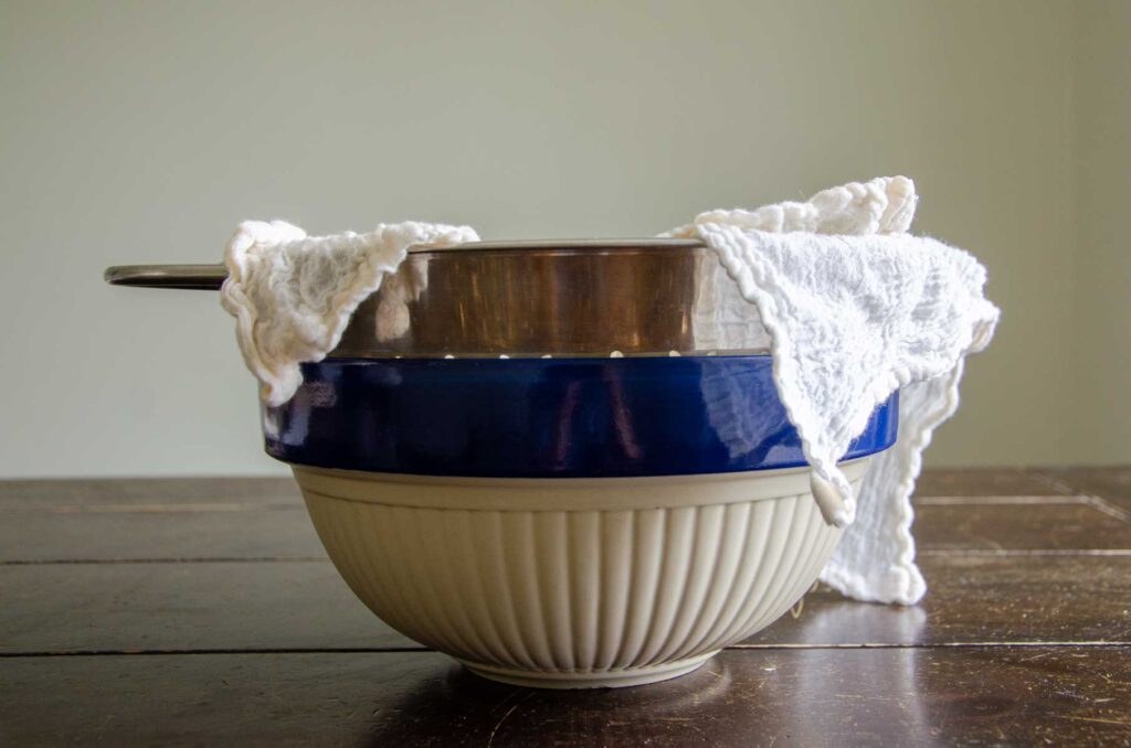cloth lined strainer over a large bowl