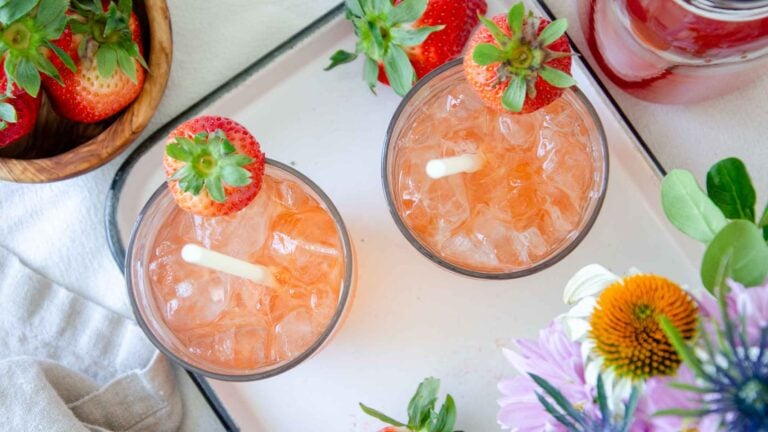 two glasses of strawberry shrub on a white tray