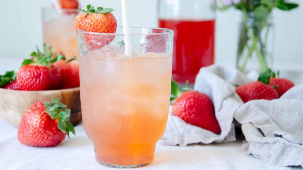 strawberry shrub in a glass with a straw