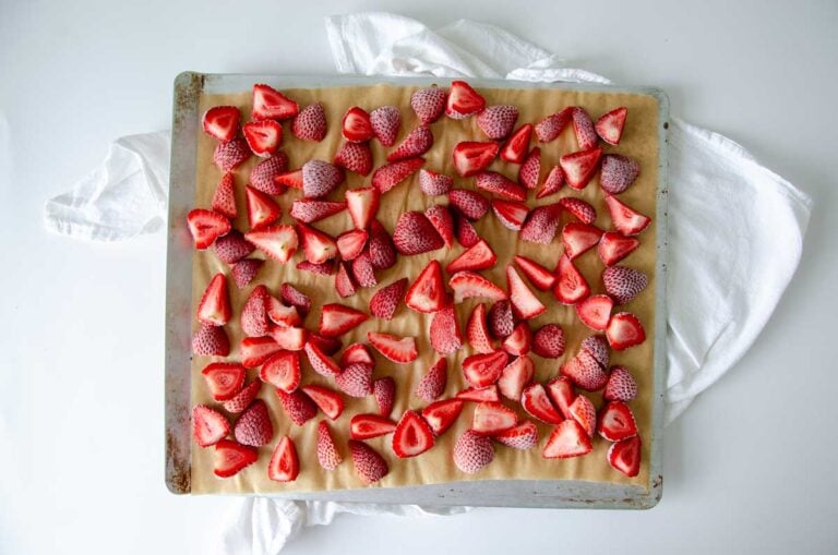Frozen strawberries on a parchment-lined baking sheet