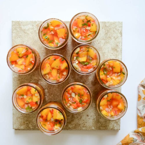 jars of peach salsa and a few whole peaches