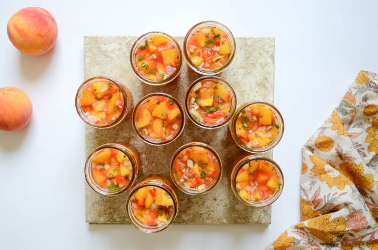 jars of peach salsa and a few whole peaches