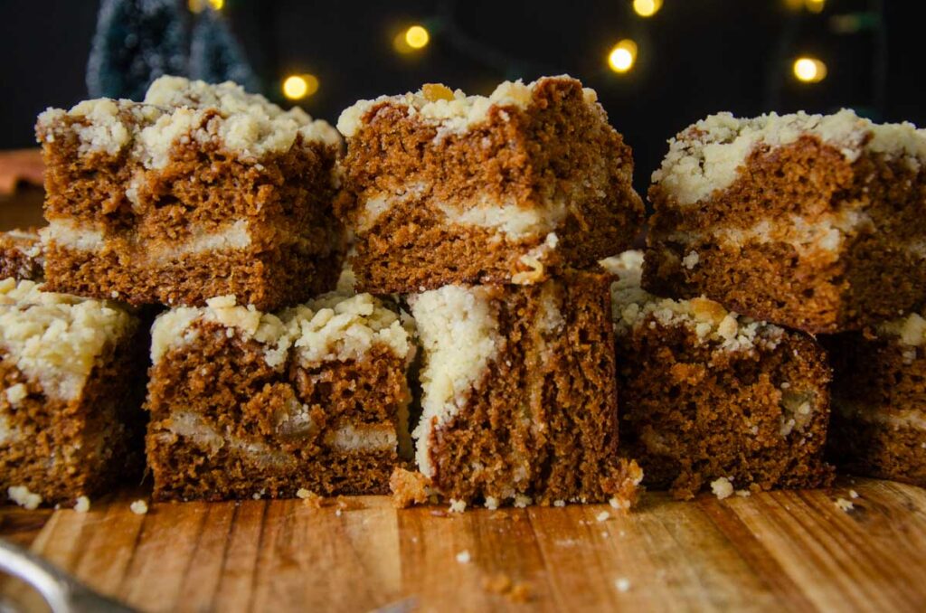 sourdough gingerbread coffee cake pieces stacked on top of each other on a wooden board