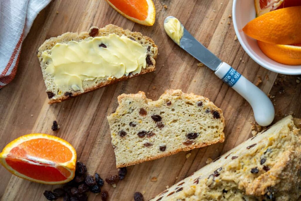 sourdough irish soda bread slices with orange slices on cutting board
