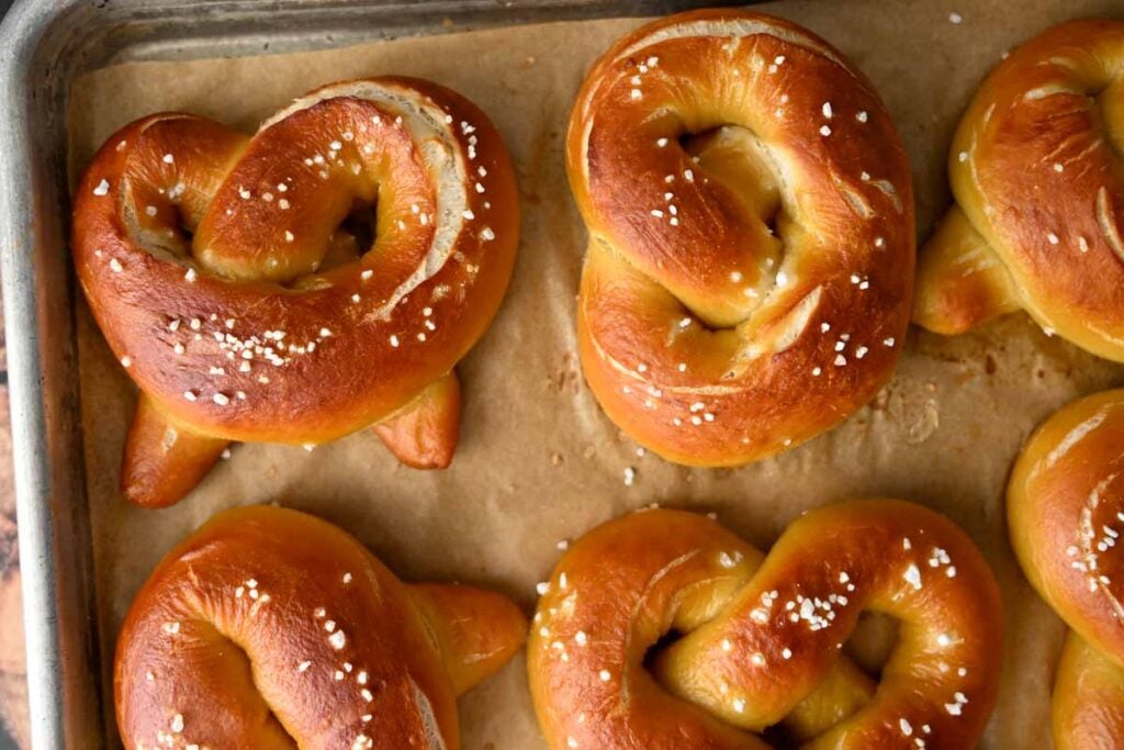 soft sourdough pretzels on a parchment lined sheet