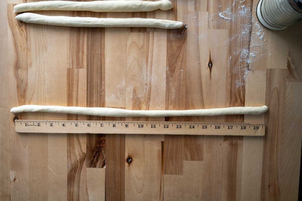 long ropes of sourdough pretzel dough next to a ruler