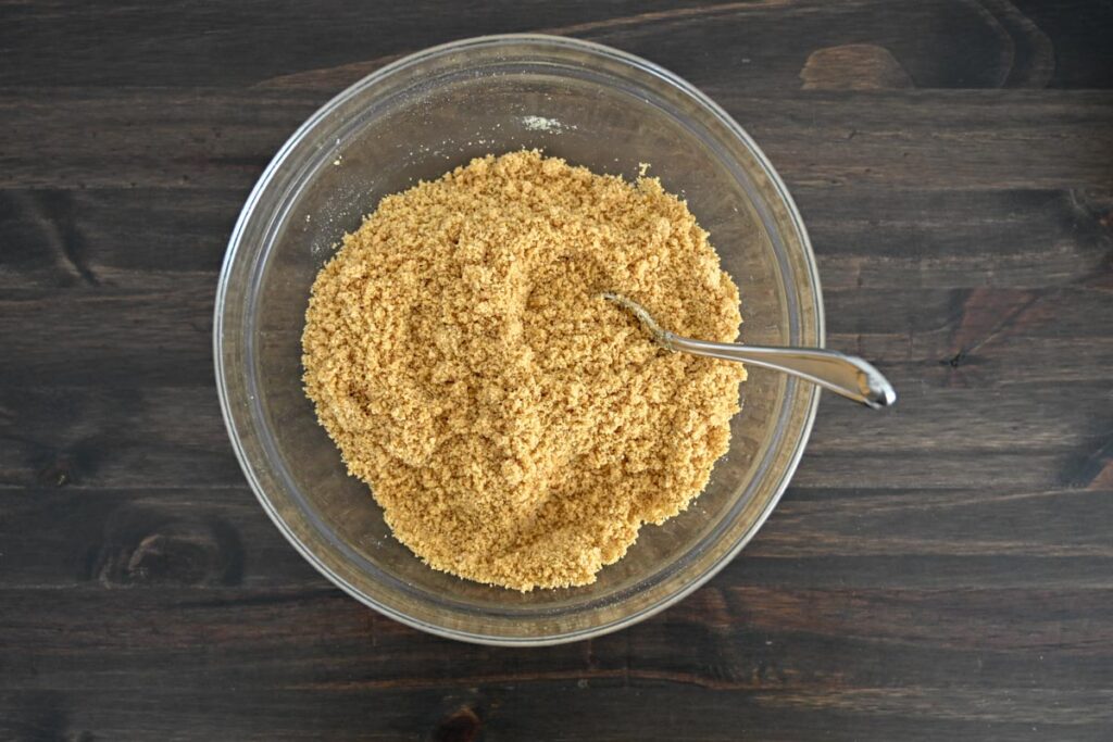 mixed graham cracker crust ingredients in a glass bowl