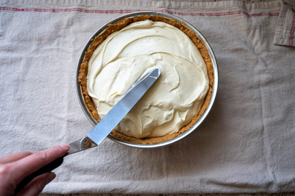 smoothing the top of easy cheesecake filling 
