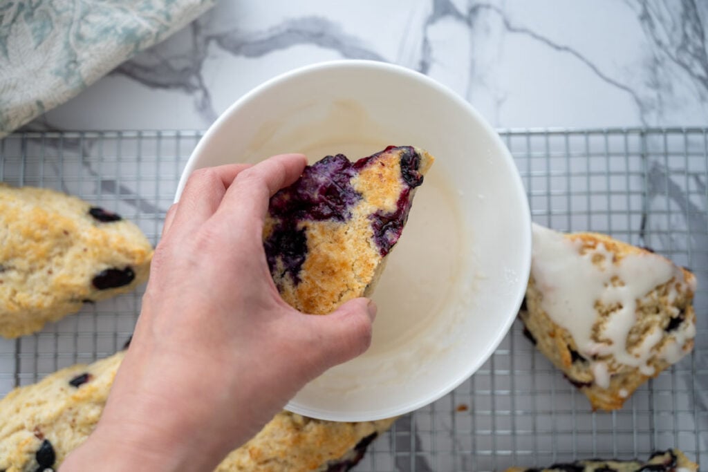 dipping scones into lemon glaze