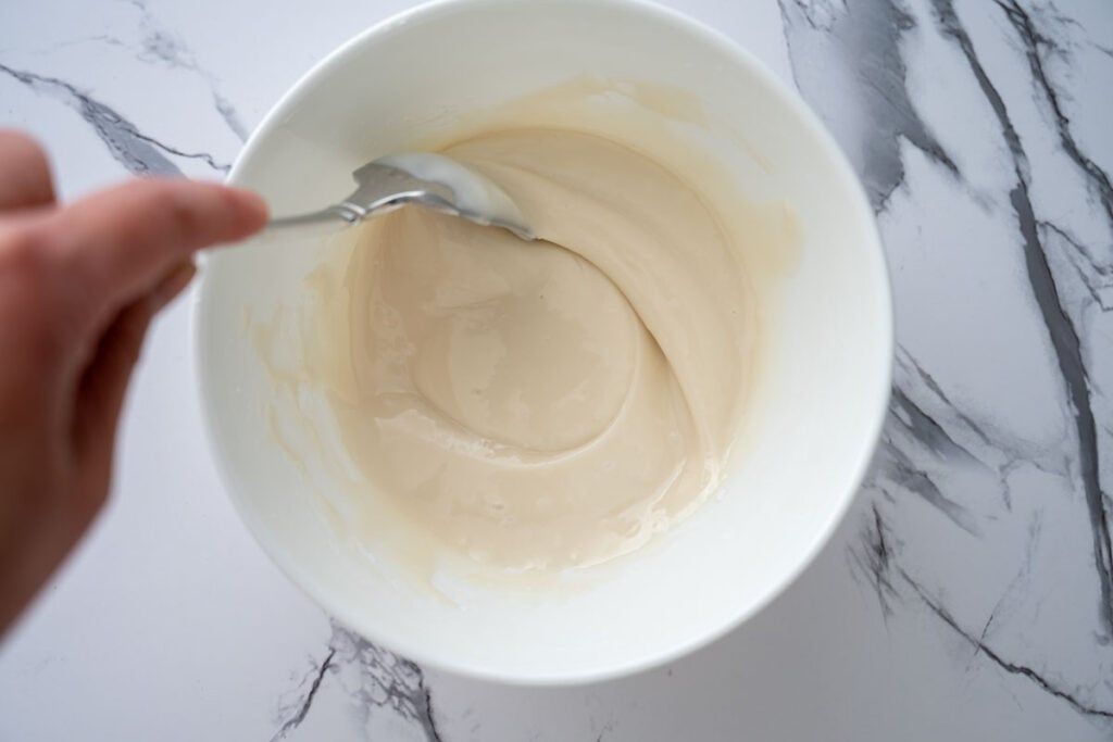 stirring lemon glaze in bowl