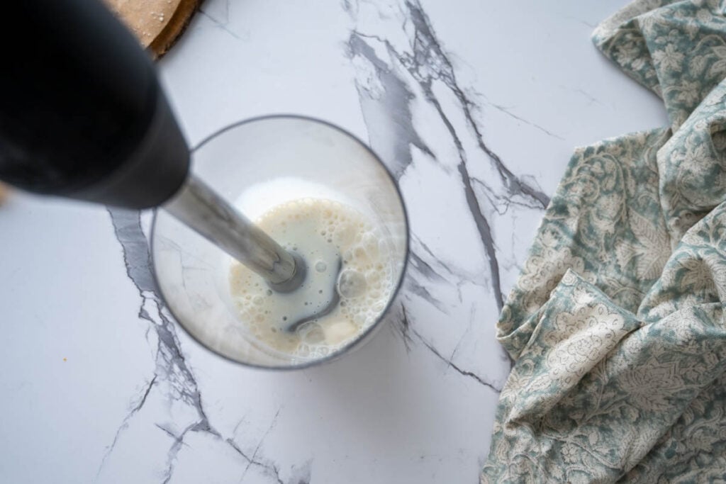 using an immersion blender to combine sourdough discard and buttermilk