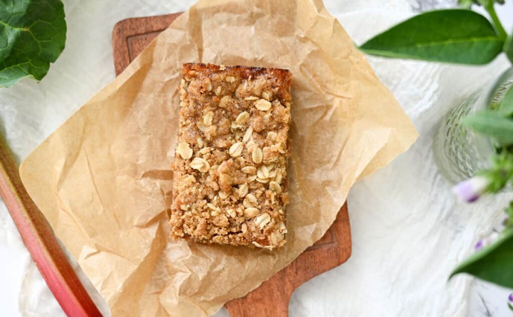 rhubarb crumble bar on a piece of parchment paper
