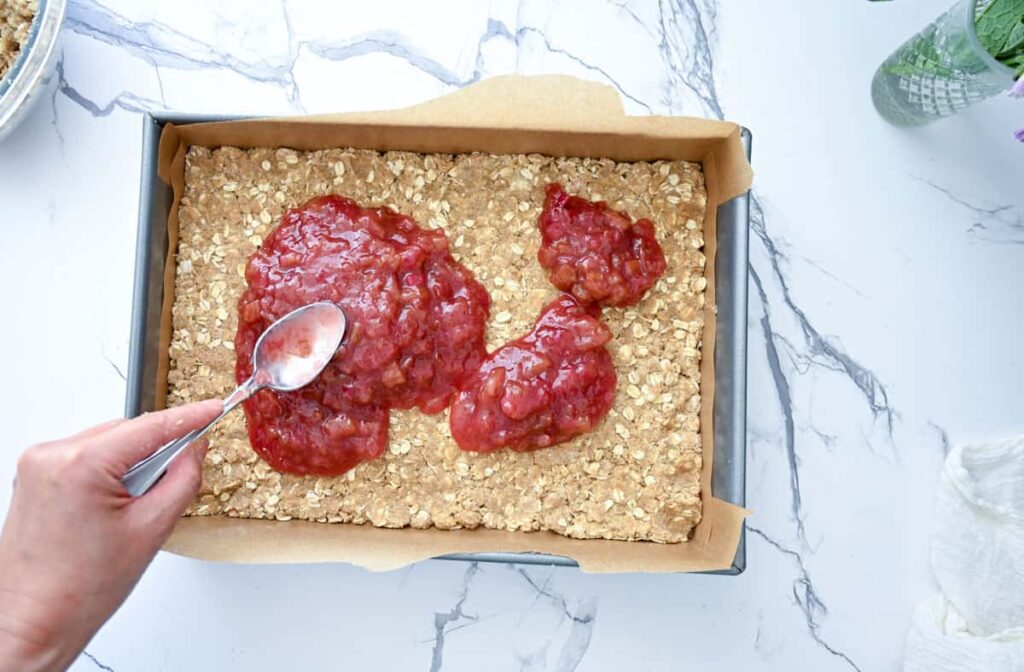 spreading rhubarb compote over crust