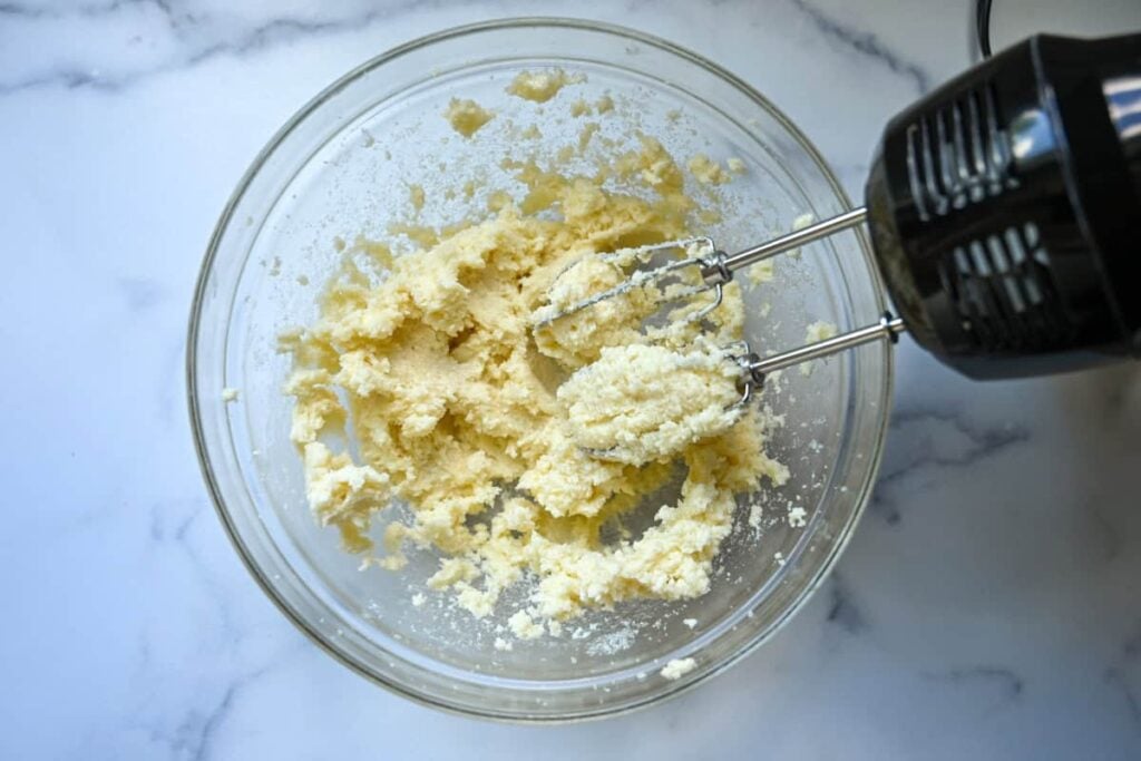 creaming butter and sugar in glass bowl with electric mixer