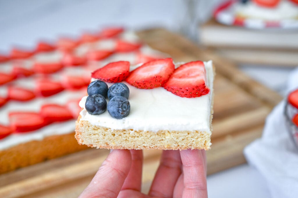 holding a piece of sourdough flag fruit pizza