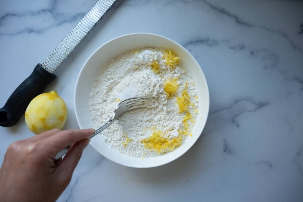 combining dry ingredients in a white bowl