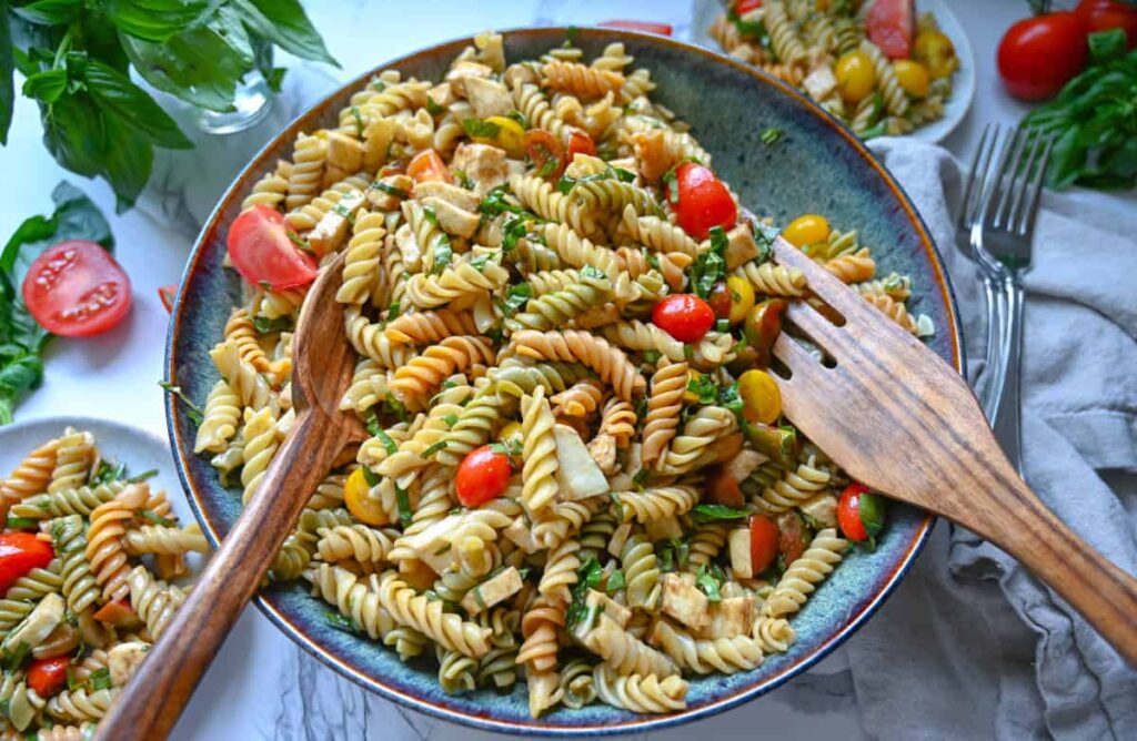 Easy caprese pasta salad in a large bowl with a wood serving spoon