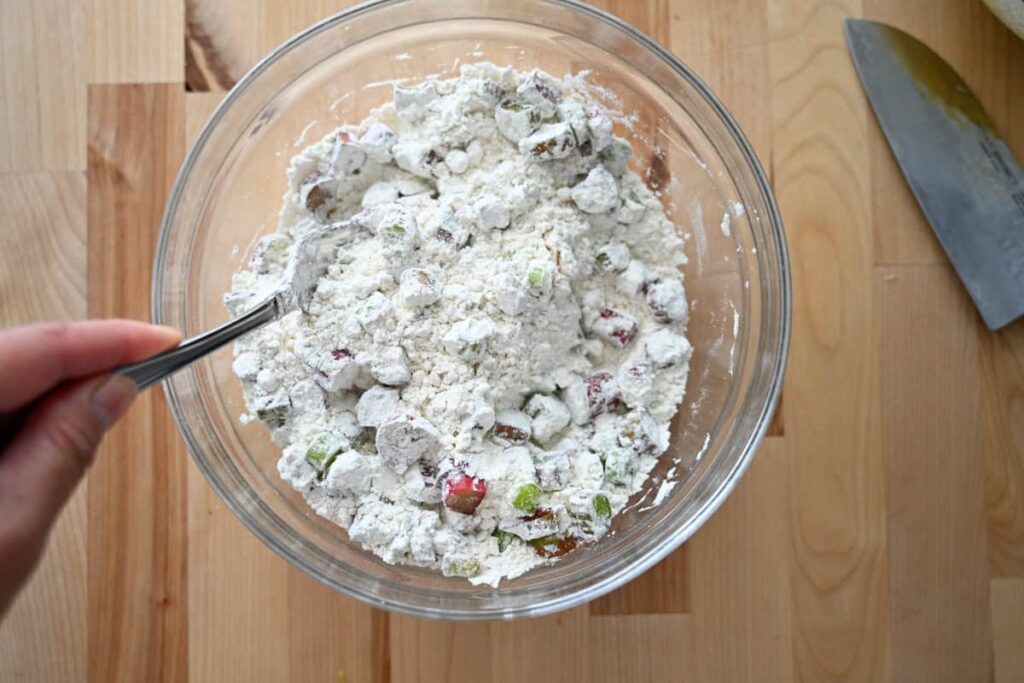 adding rhubarb pieces into dry ingredients 