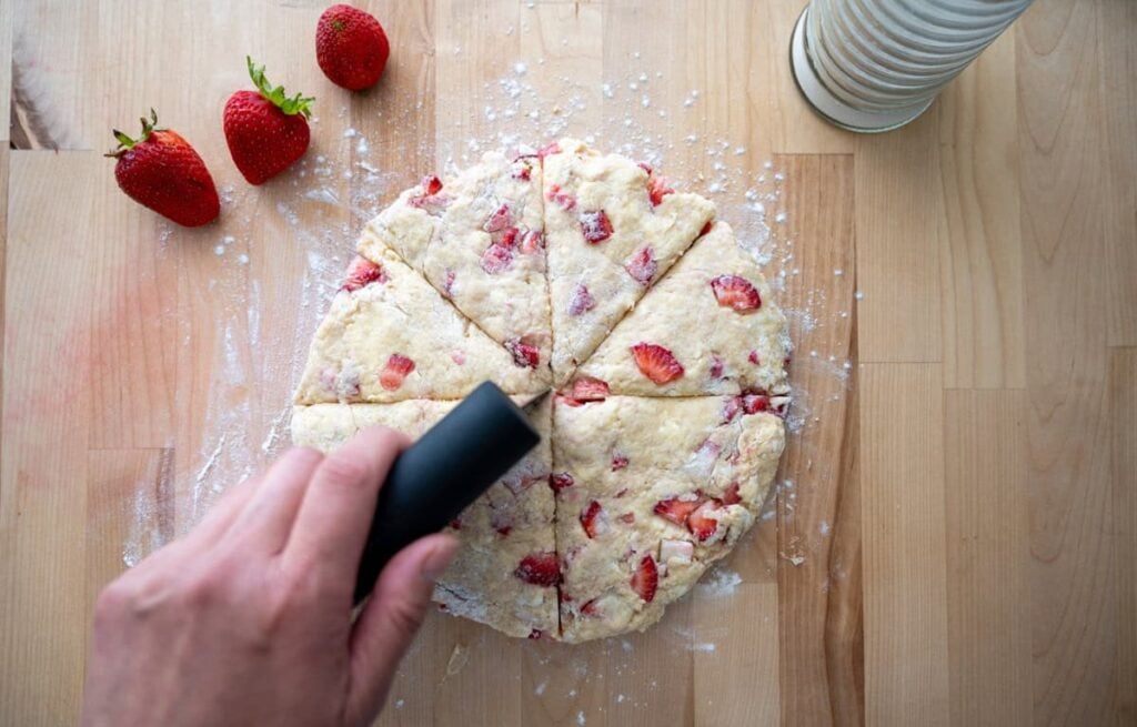 cutting sourdough strawberry scone dough into triangles