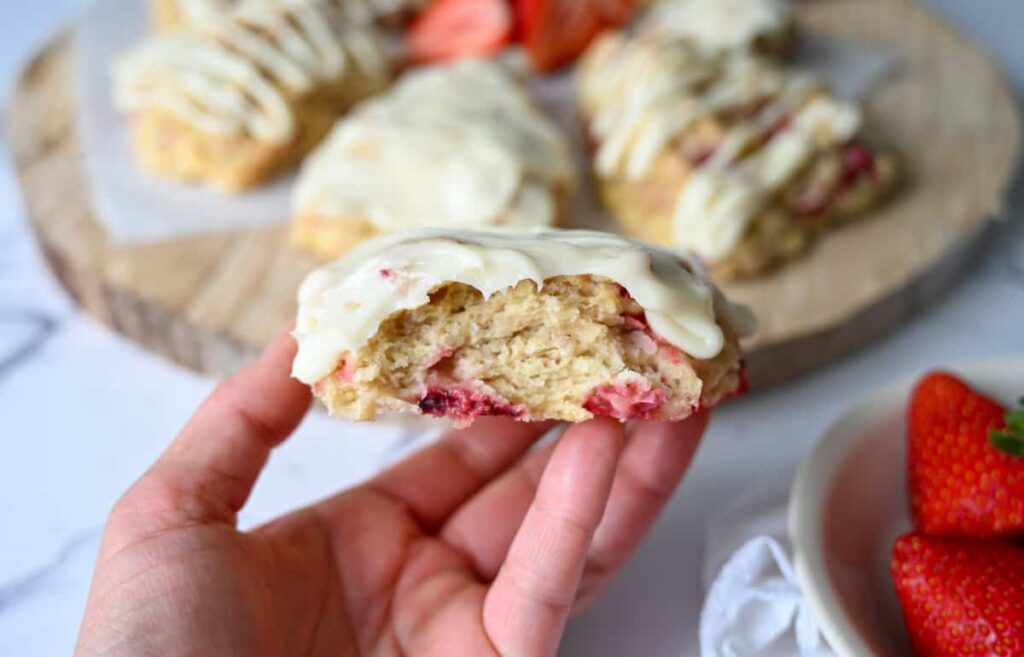 holding a piece of sourdough strawberry scone