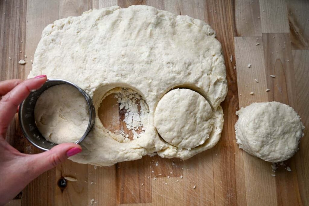 cutting sourdough shortcake dough into circles with a circle cutter