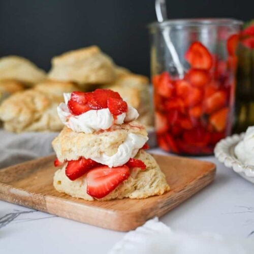 sourdough strawberry shortcake with strawberries and whipped cream on a wood plate