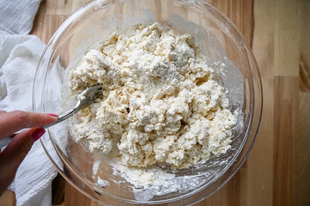 mixing sourdough shortcake dough in a glass bowl with a fork