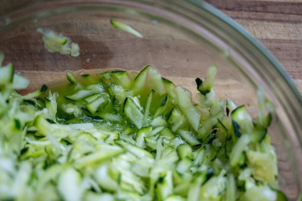 salted grated zucchini in a bowl 