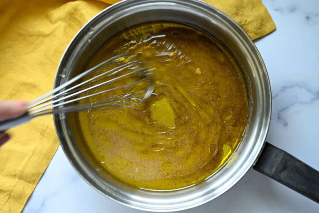 whisking the cowboy caviar dressing in a small saucepan