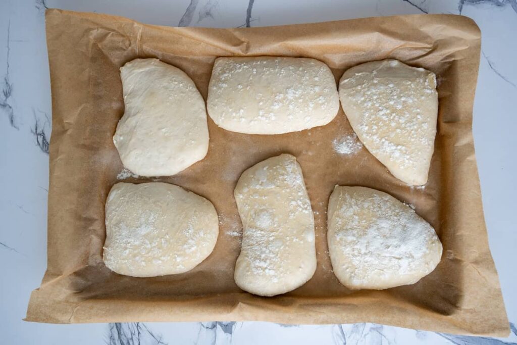 proofed sourdough ciabatta dough on a parchment lined baking sheet