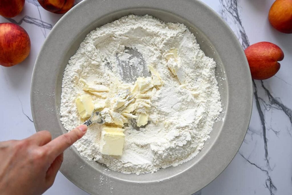 mixing dry ingredients for sourdough peach cobbler in a wide, shallow bowl